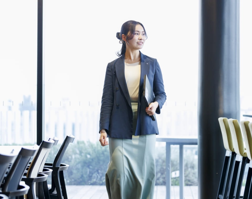 女性がパソコンを持って立っている写真