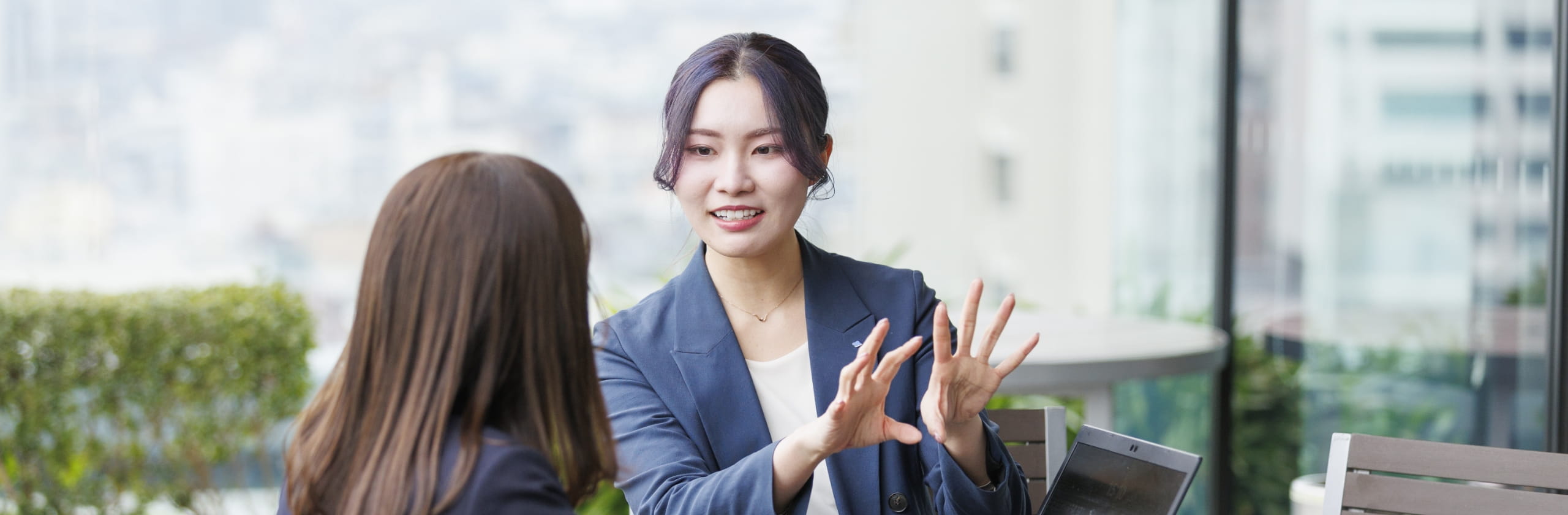 女性がジェスチャーで説明をしている写真